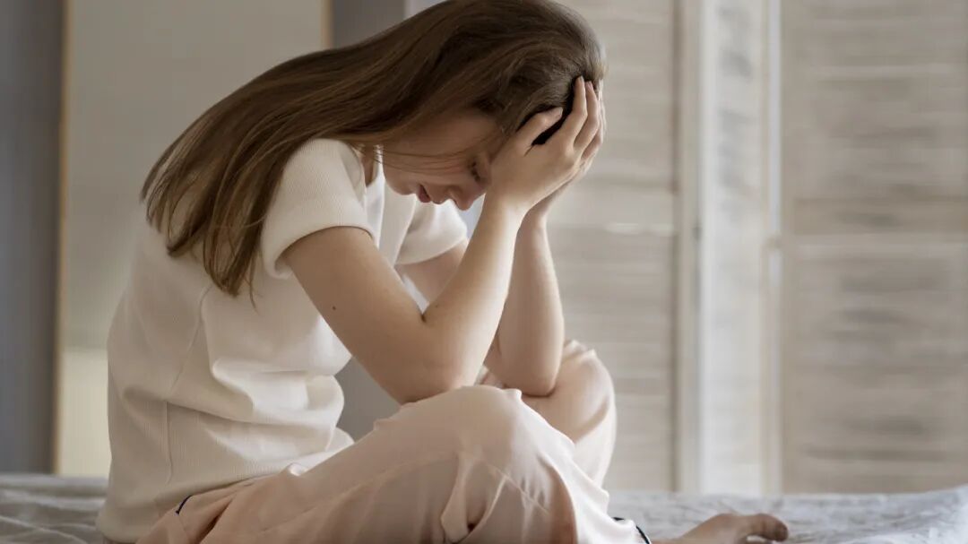anxious-woman-sitting-bed-full-shot.jpg